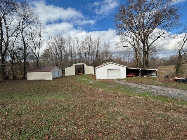 7030 Asbury Glimp Road Ripley, TN 38063 - Photo 4 of 22 View of yard with an outbuilding, a garage, and driveway