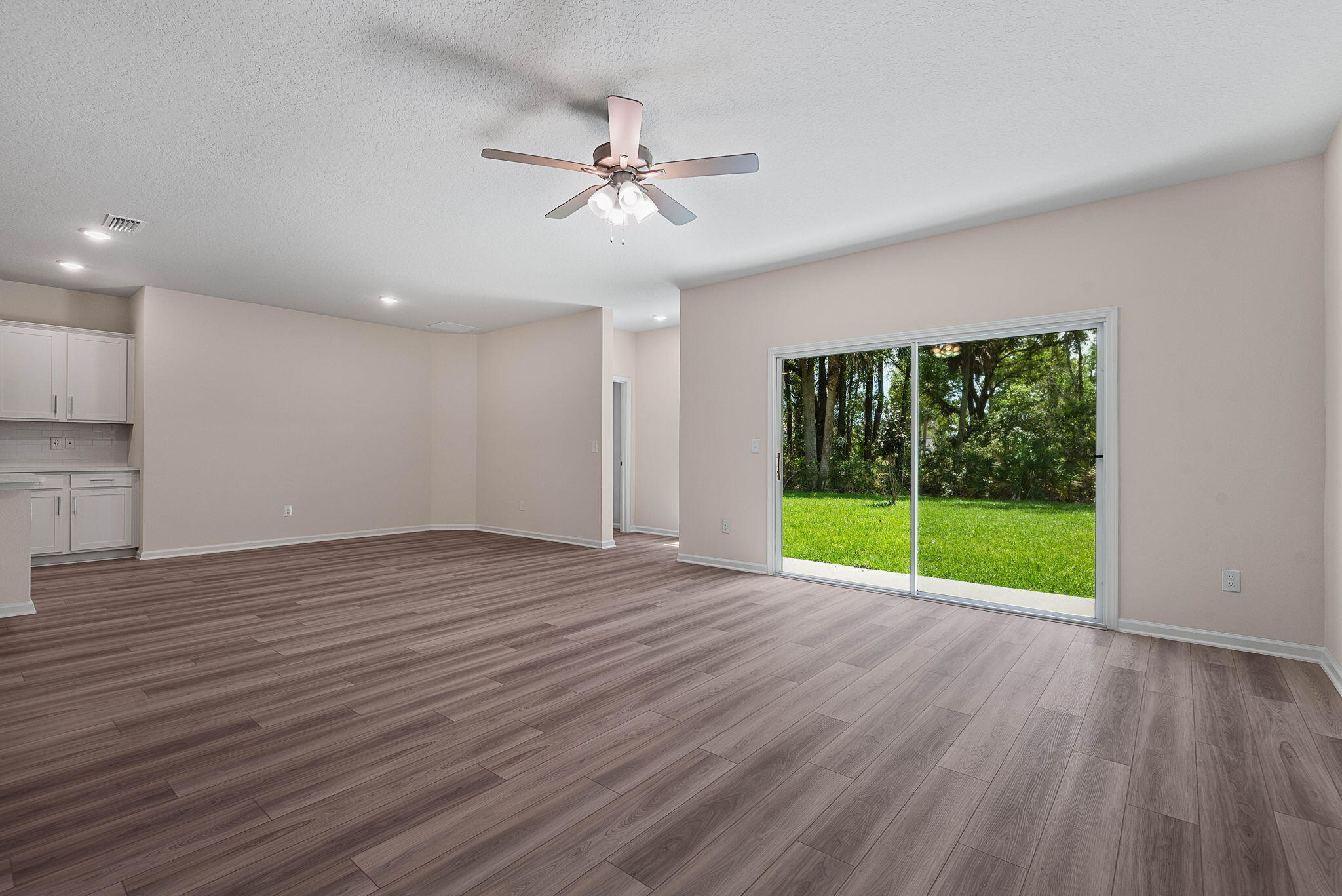 46 Poplar Drive Palm Coast, FL 32164 - Photo 11 of 59 a view of an empty room with wooden floor and fan