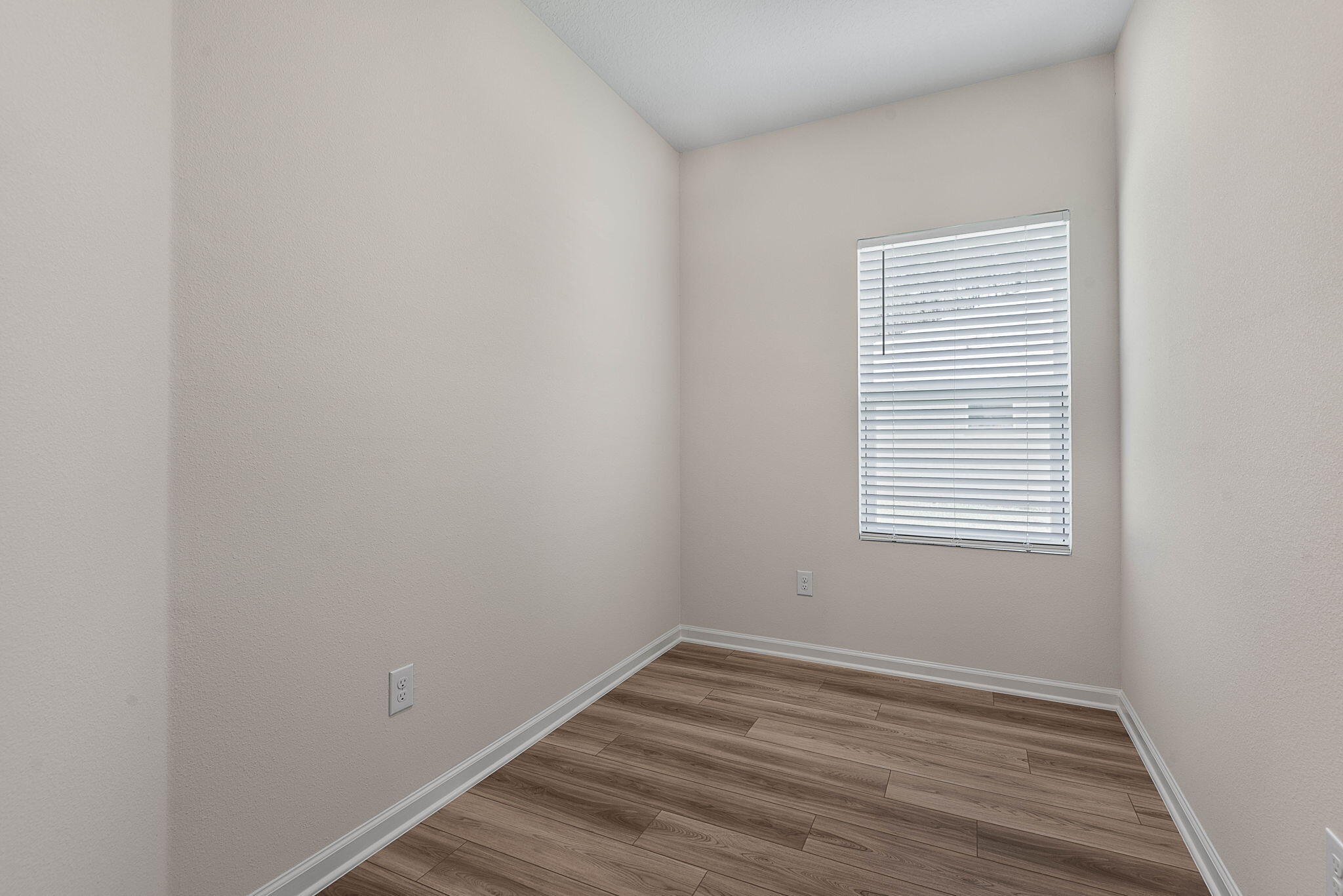 46 Poplar Drive Palm Coast, FL 32164 - Photo 13 of 59 a view of an empty room with wooden floor and a window