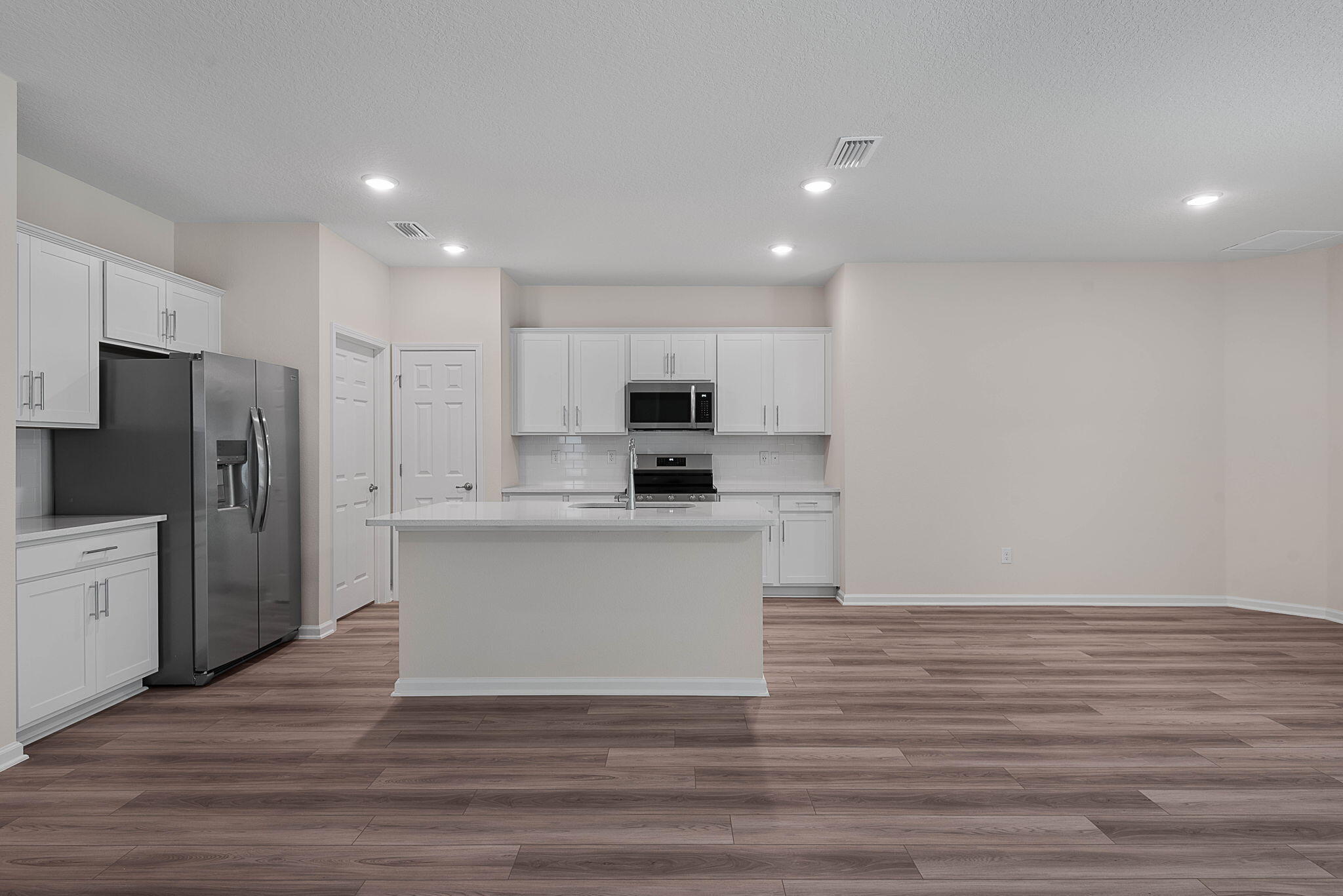 46 Poplar Drive Palm Coast, FL 32164 - Photo 15 of 59 a kitchen with stainless steel appliances granite countertop a refrigerator sink and white cabinets