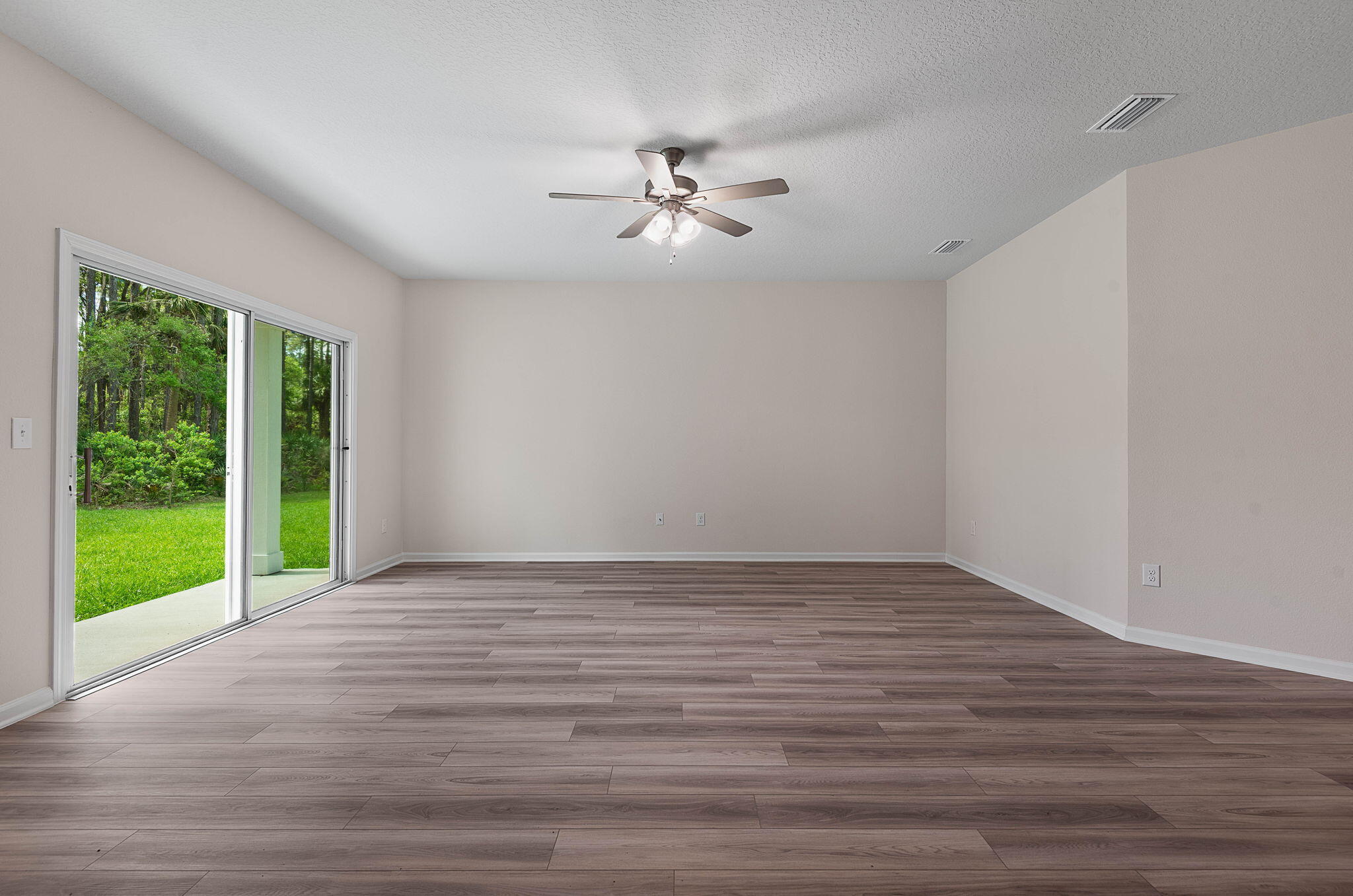 46 Poplar Drive Palm Coast, FL 32164 - Photo 7 of 59 a view of an empty room with wooden floor and a window