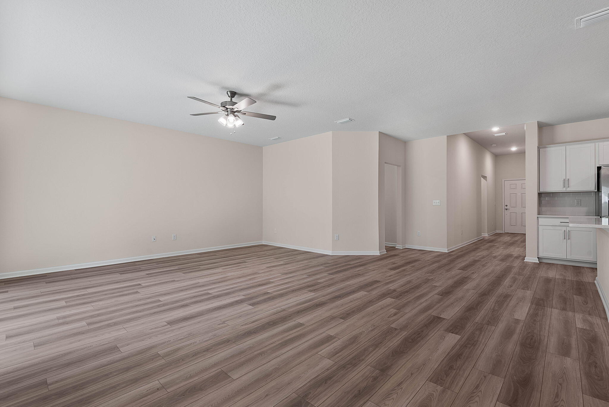 46 Poplar Drive Palm Coast, FL 32164 - Photo 8 of 59 a view of empty room with wooden floor and fan