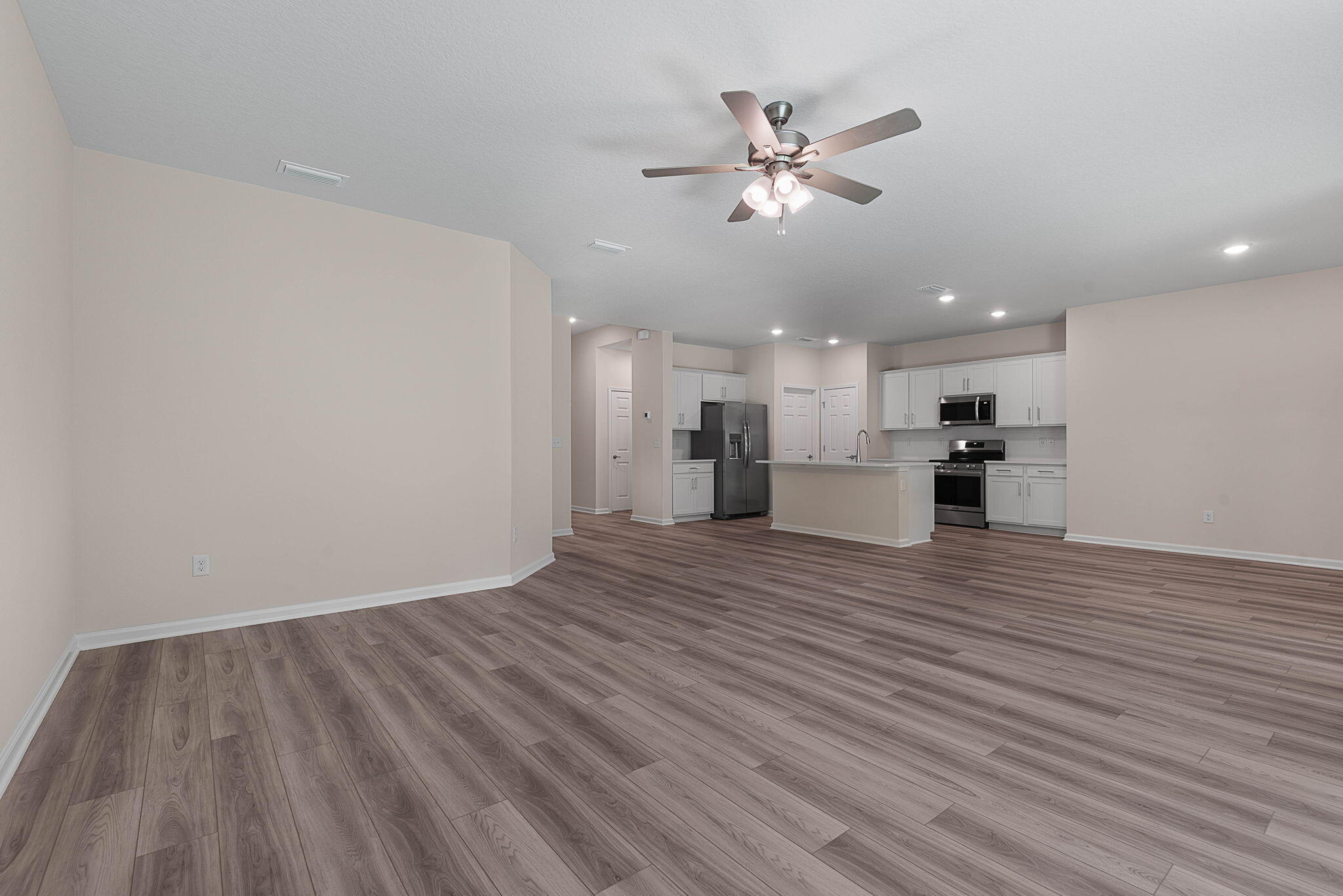46 Poplar Drive Palm Coast, FL 32164 - Photo 9 of 59 a view of empty room with wooden floor and kitchen view