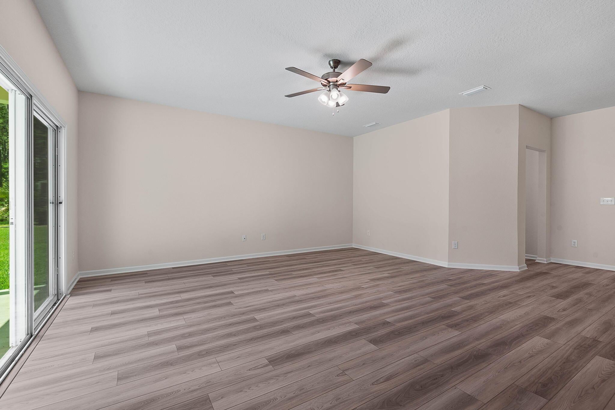 46 Poplar Drive Palm Coast, FL 32164 - Photo 10 of 59 a view of an empty room with wooden floor and a window