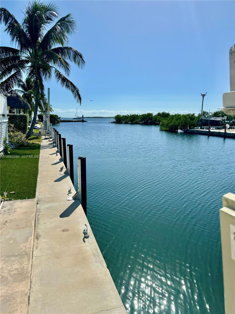 72 Ocean Drive Key Largo, FL 33037 - Photo 22 of 36 a backyard of a house with lots of green space and lake view
