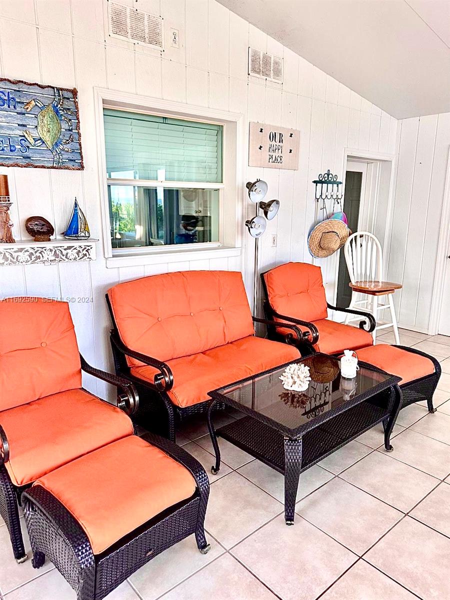 72 Ocean Drive Key Largo, FL 33037 - Photo 30 of 36 a room with furniture a rug and a window