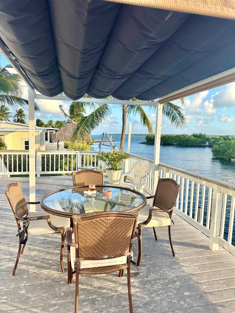 72 Ocean Drive Key Largo, FL 33037 - Photo 3 of 36 a view of a porch with furniture and wooden floor