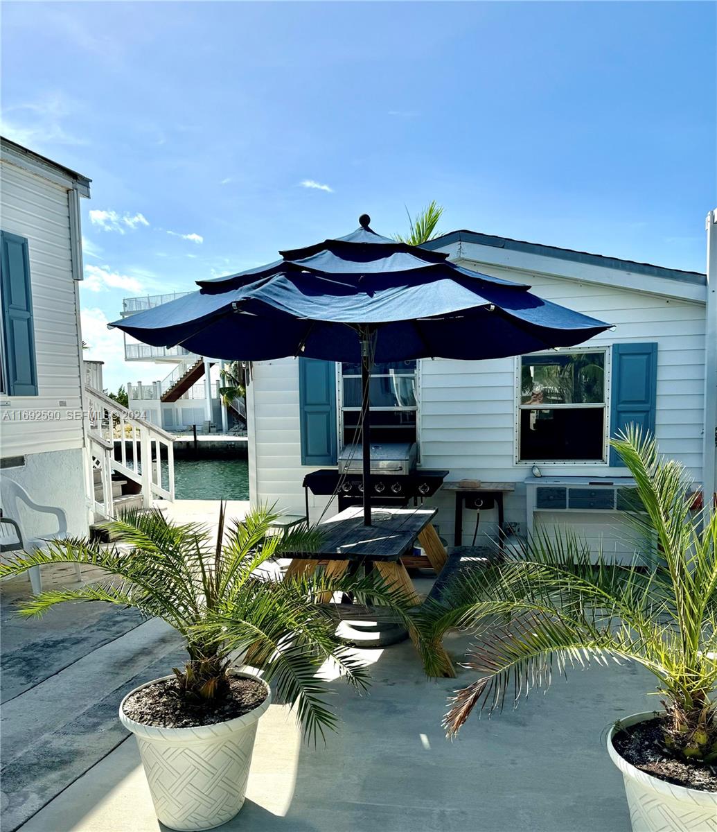 72 Ocean Drive Key Largo, FL 33037 - Photo 33 of 36 a patio with a table and chairs under an umbrella