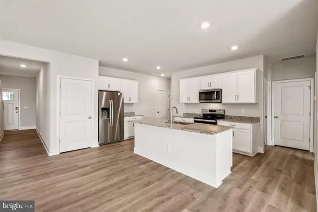 a kitchen with stainless steel appliances a refrigerator sink and microwave