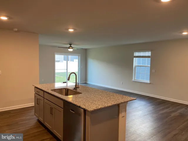 a kitchen with stainless steel appliances granite countertop a sink a stove and wooden floor