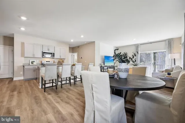 a kitchen with a dining table chairs and refrigerator