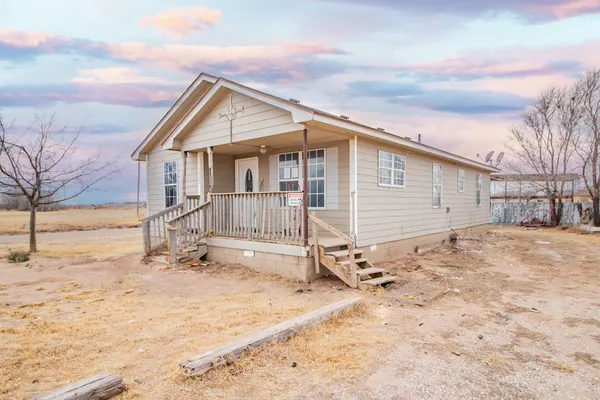 a view of a house with a yard covered in snow