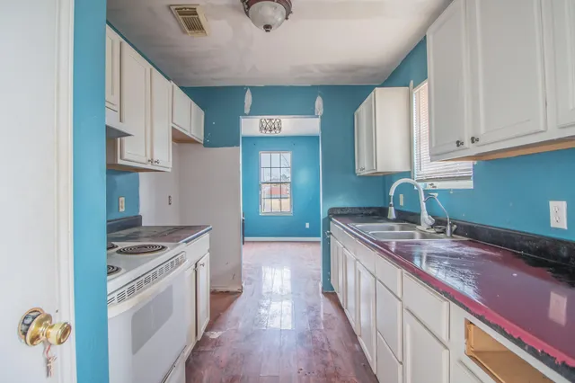a kitchen with granite countertop a sink stove and cabinets