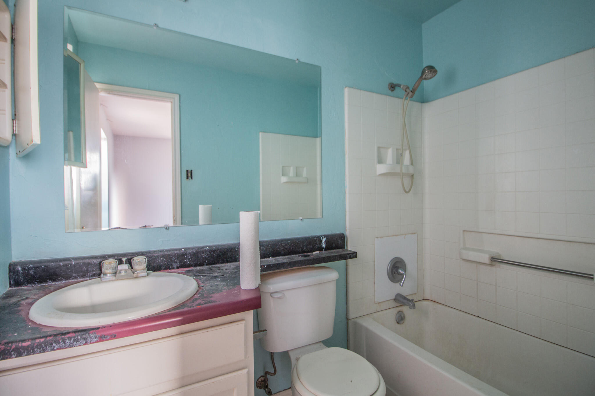 1355 South 3rd Street Slaton, TX 79364 - Photo 10 of 14 a bathroom with a granite countertop sink toilet mirror and bathtub