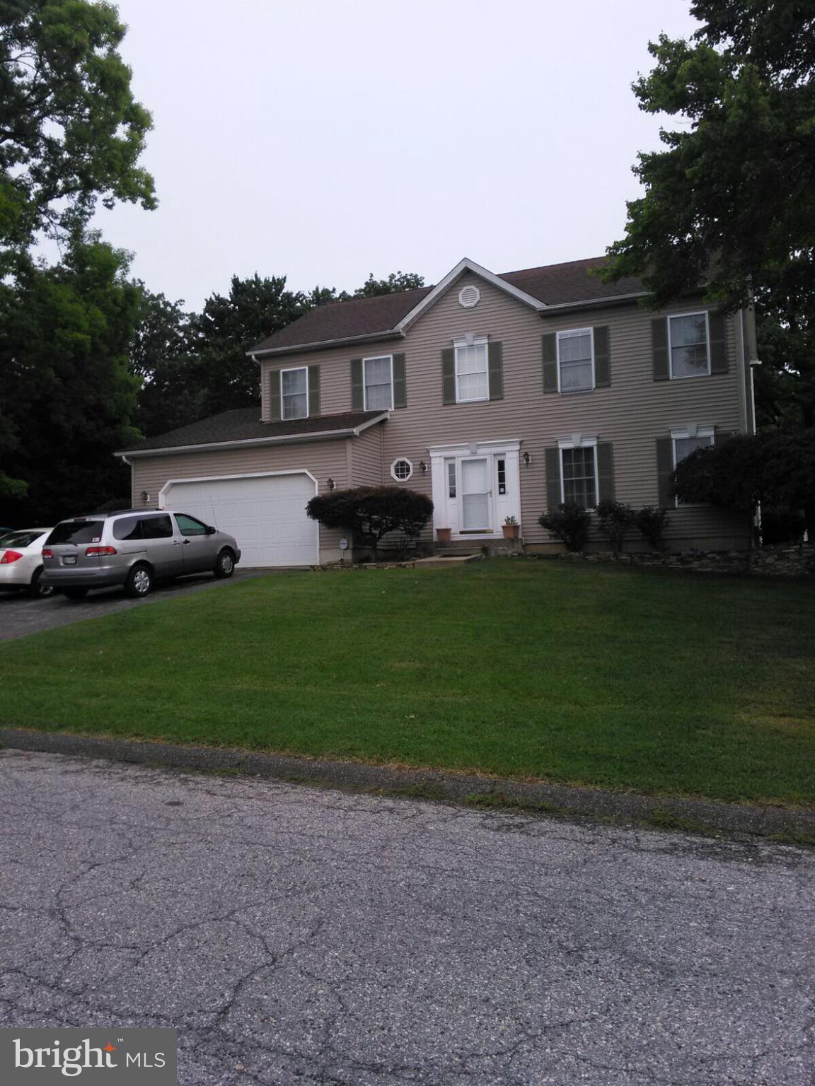 7006 Pinecrest Road Baltimore, MD 21228 - Photo 2 of 30 a front view of a house with a garden and trees
