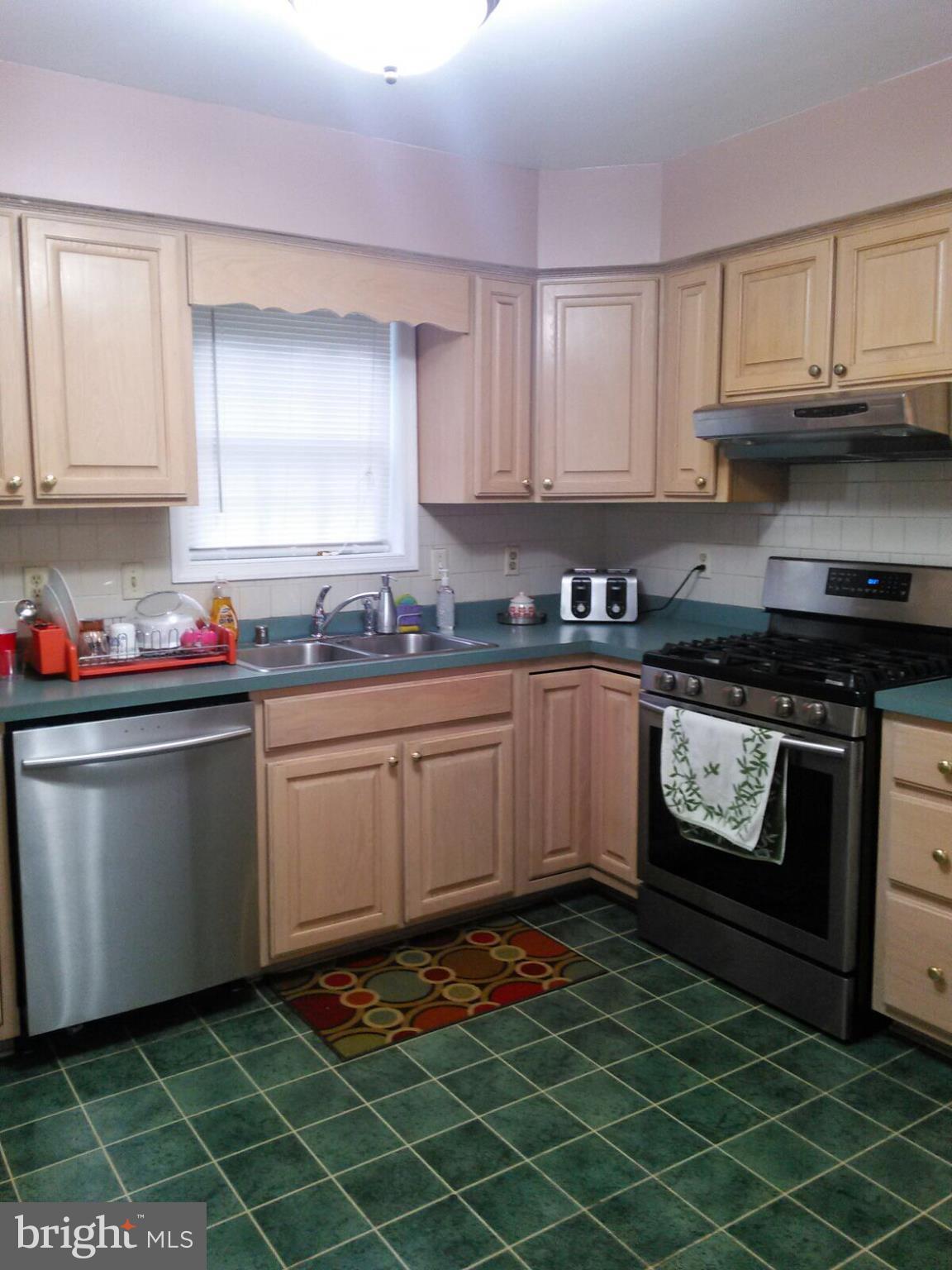 7006 Pinecrest Road Baltimore, MD 21228 - Photo 11 of 30 a kitchen with a sink a stove and cabinets