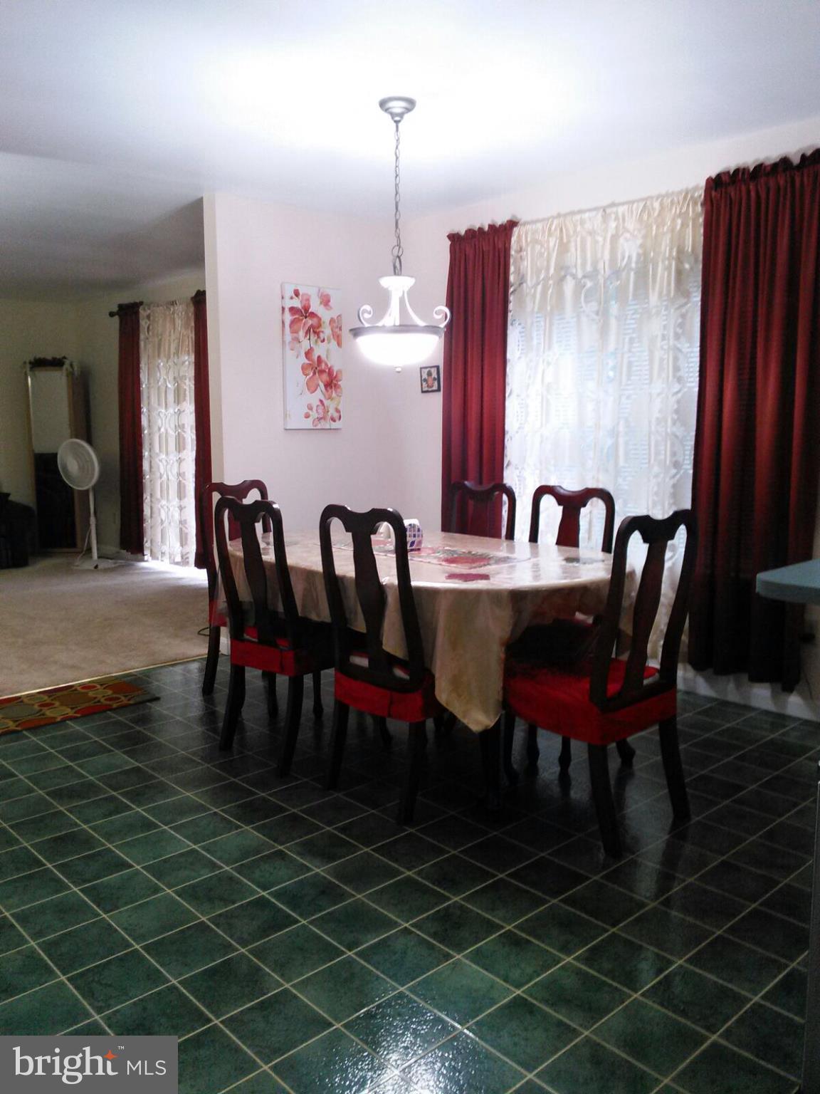 7006 Pinecrest Road Baltimore, MD 21228 - Photo 9 of 30 a dining room with furniture a rug and a chandelier