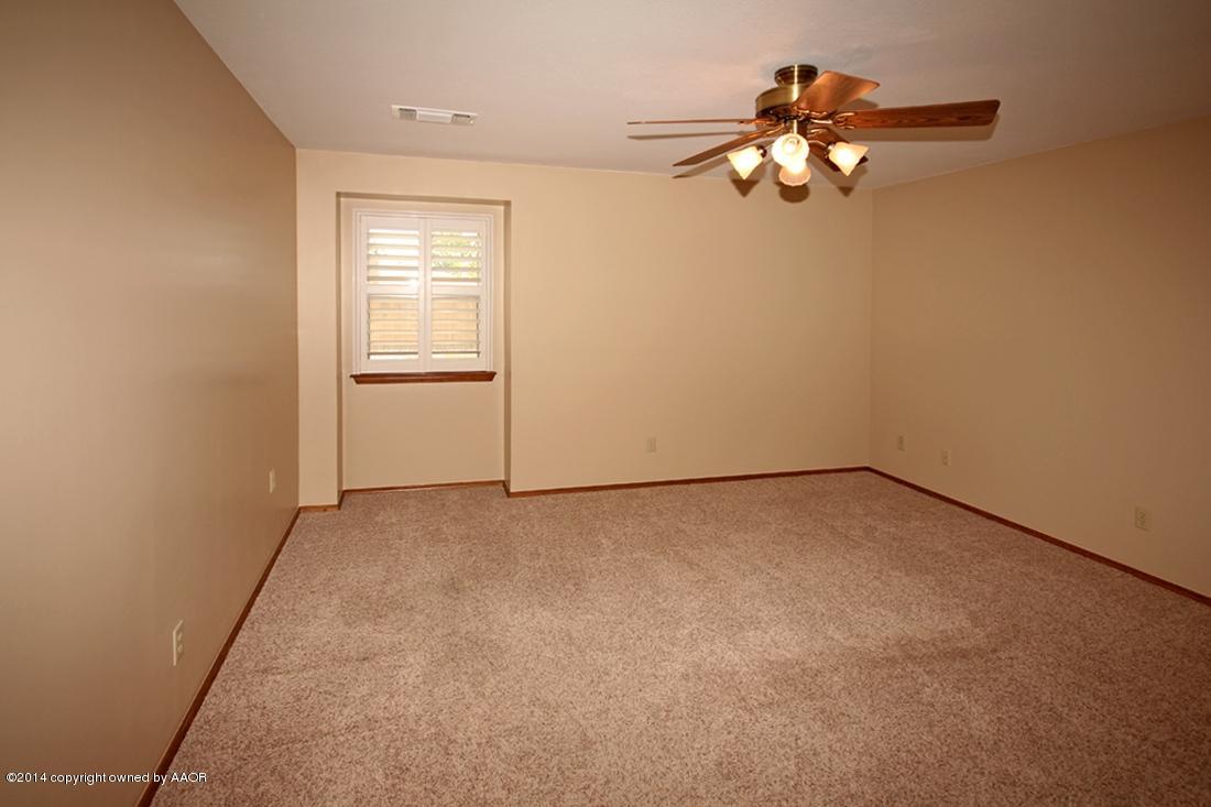 8105 Marni Trail Amarillo, TX 79110 - Photo 12 of 30 an empty room with a chandelier fan and windows