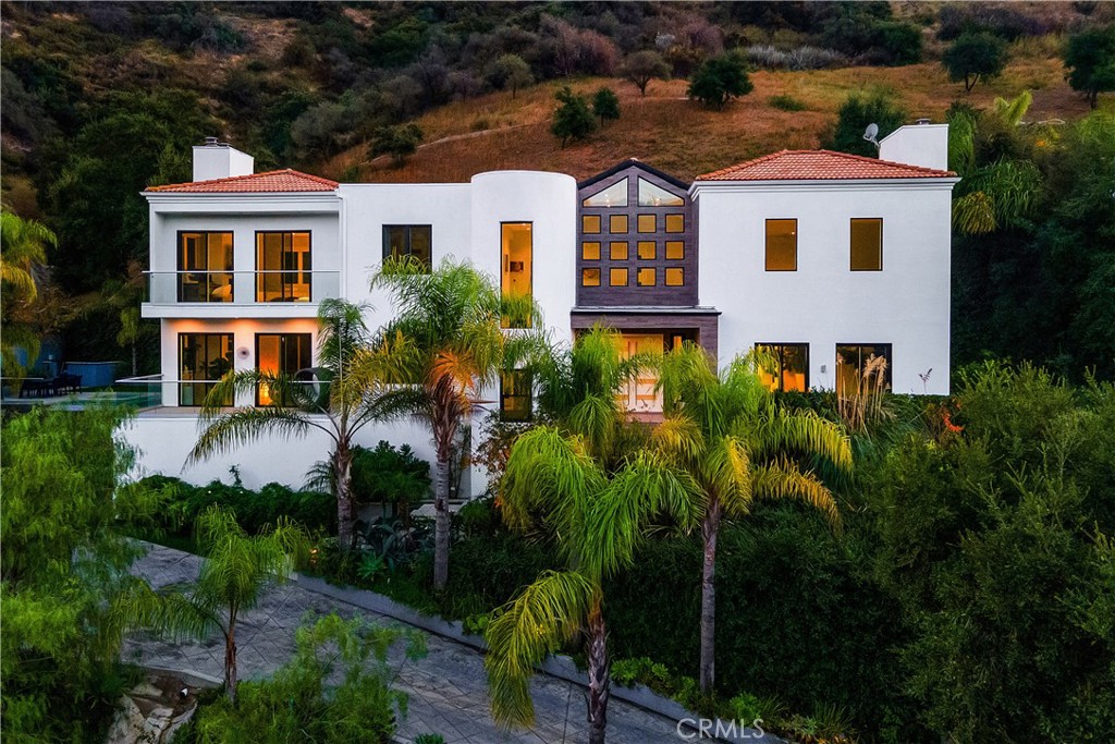 a front view of a house with a yard and potted plants