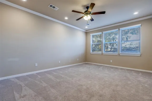 an empty room with a ceiling fan and windows