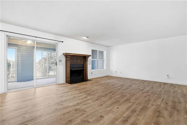 wooden floor fireplace and windows in an empty room