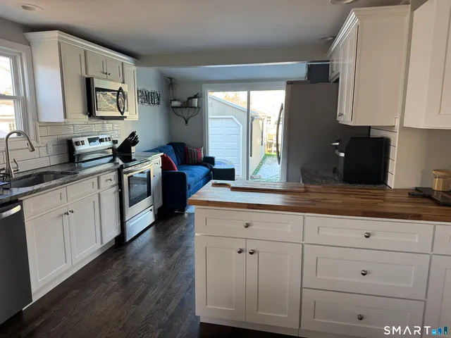 a kitchen with white cabinets and sink