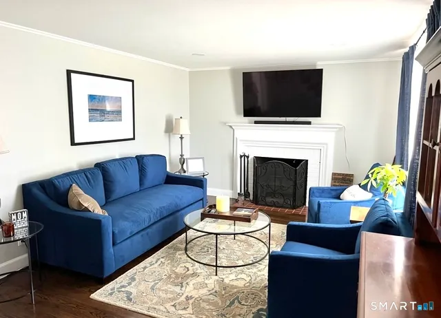 a living room with furniture a fireplace and a flat screen tv