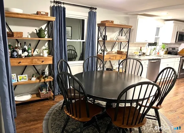 a dining room with furniture a chandelier and wooden floor