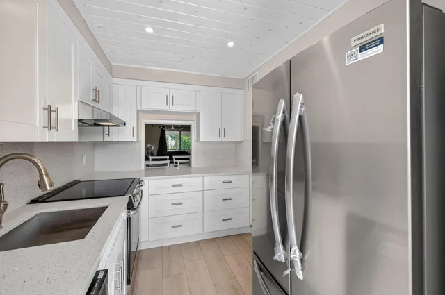 a kitchen with stainless steel appliances granite countertop a refrigerator and a sink