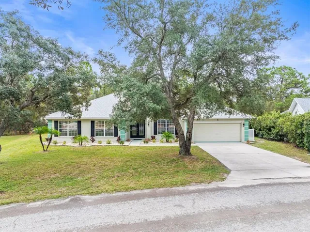 a front view of a house with a yard and trees