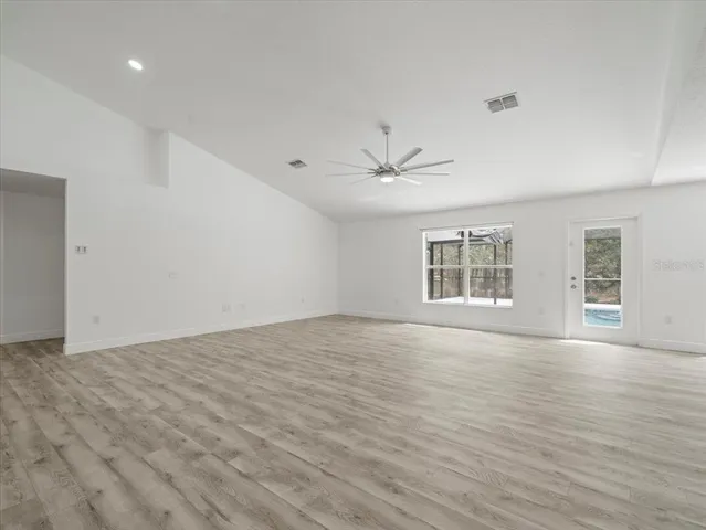 a view of empty room with wooden floor and ceiling fan