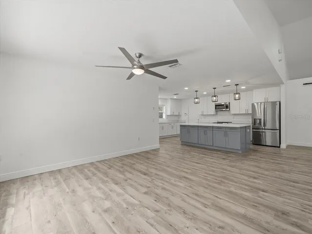 a kitchen with white cabinets and a window