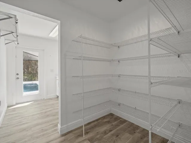 a view of a room with wooden floor and mirror