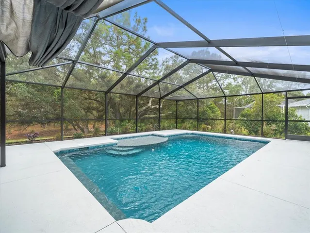 an aerial view of residential house with outdoor space and trees all around