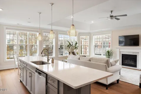 a living room with furniture a large window and a chandelier