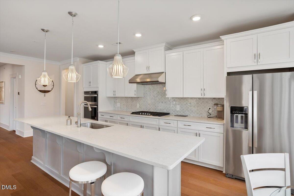 10530 Sablewood Drive, Unit 215 Raleigh, NC 27617 - Photo 14 of 40 a kitchen with a sink a stove a refrigerator and white cabinets