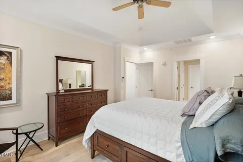 a bedroom with a bed and a mirror on the dresser