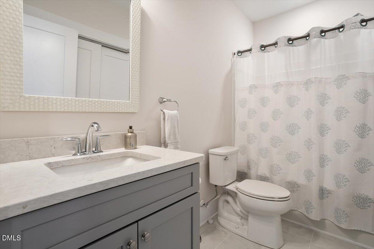 10530 Sablewood Drive, Unit 215 Raleigh, NC 27617 - Photo 35 of 40 a bathroom with a sink a toilet and a mirror