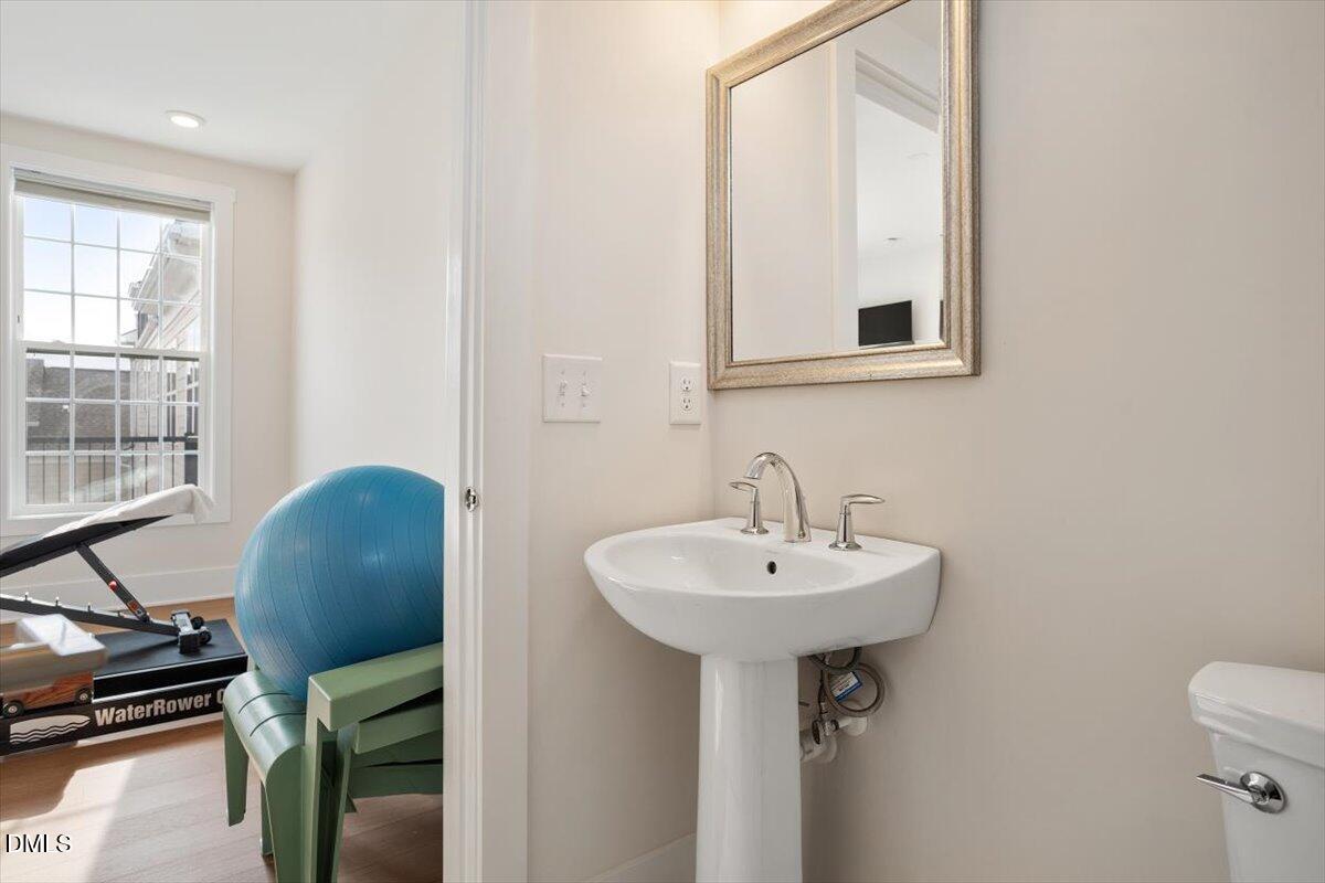 10530 Sablewood Drive, Unit 215 Raleigh, NC 27617 - Photo 38 of 40 a bathroom with a sink a mirror and a toilet