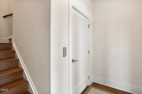 a view of a hallway with wooden floor and entryway