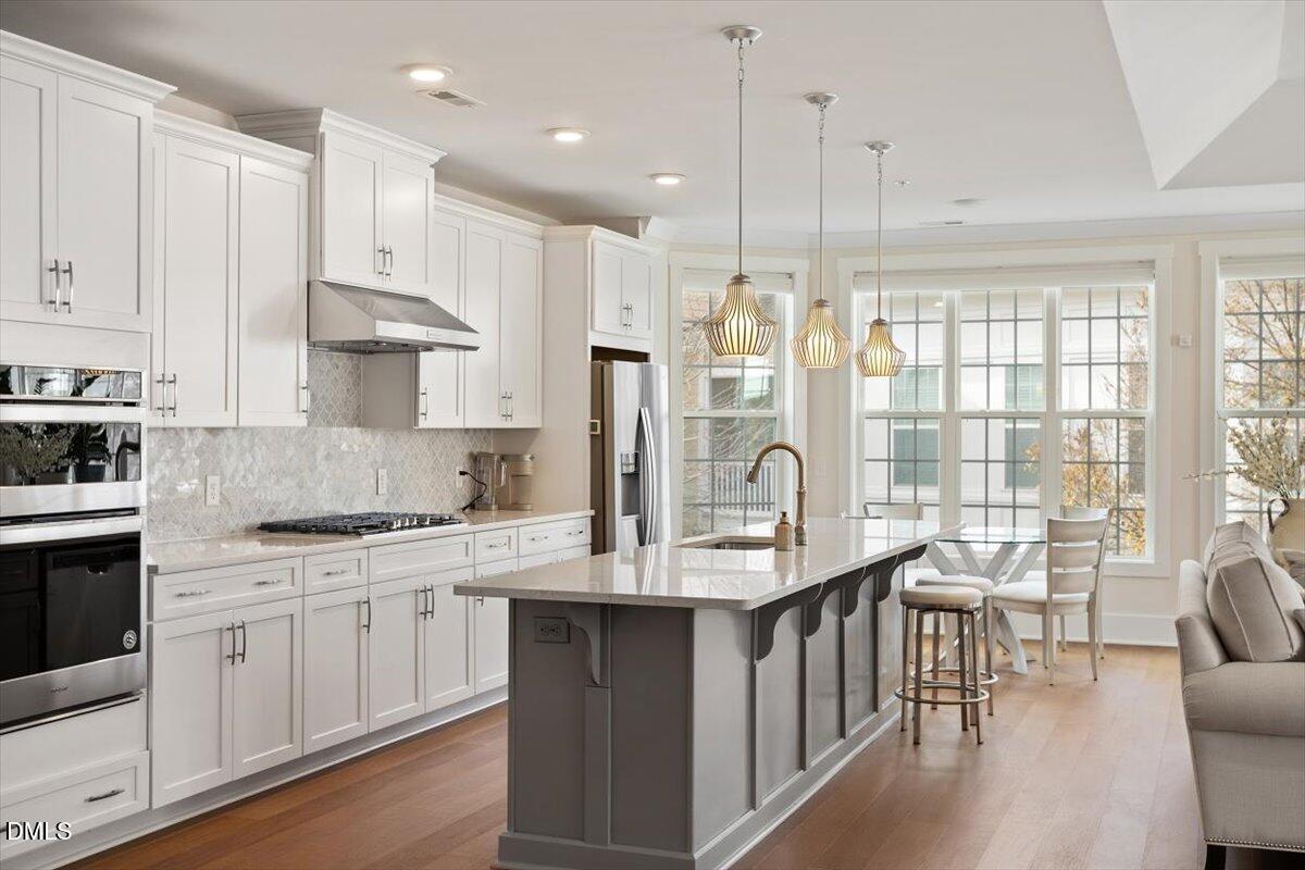 10530 Sablewood Drive, Unit 215 Raleigh, NC 27617 - Photo 10 of 40 a kitchen with stainless steel appliances granite countertop a stove a sink dishwasher and a refrigerator with wooden floor