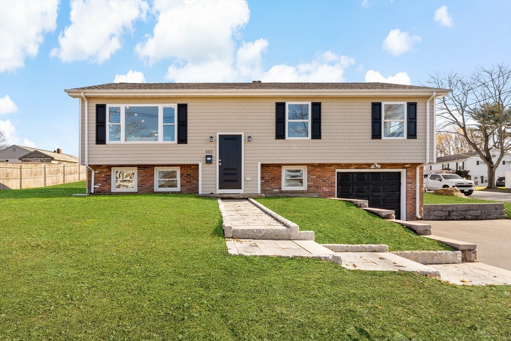 a front view of house with yard and green space