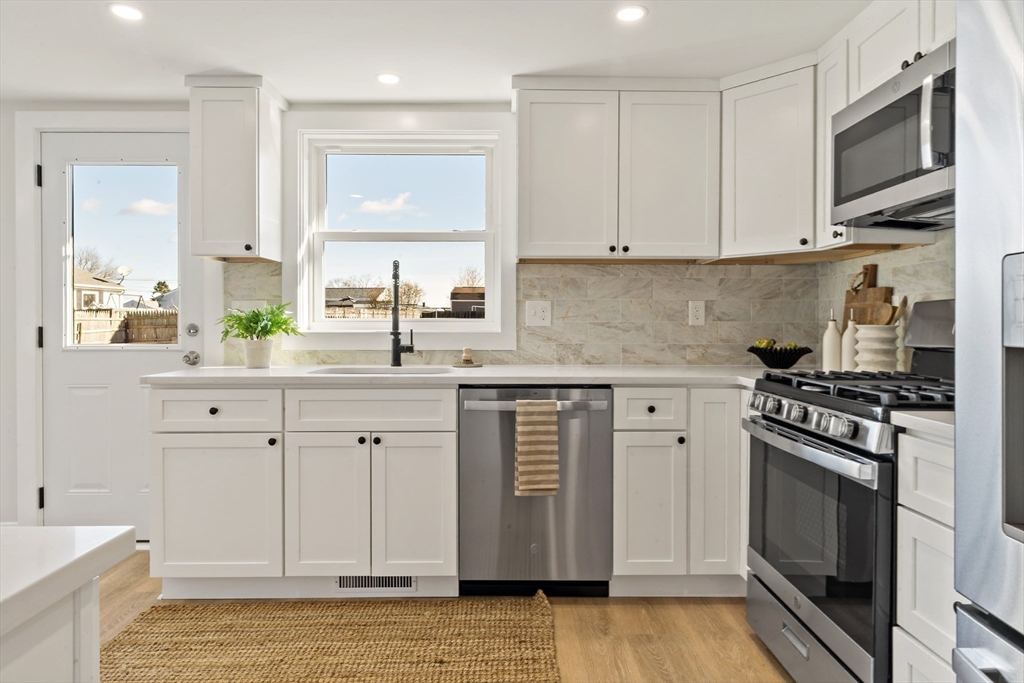 602 Regan Road Somerset, MA 02726 - Photo 16 of 35 a kitchen with stainless steel appliances white cabinets and a stove top oven
