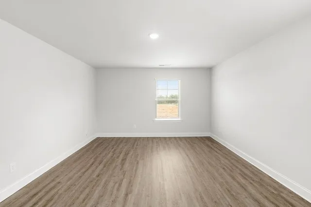 a view of a room with wooden floor and white walls
