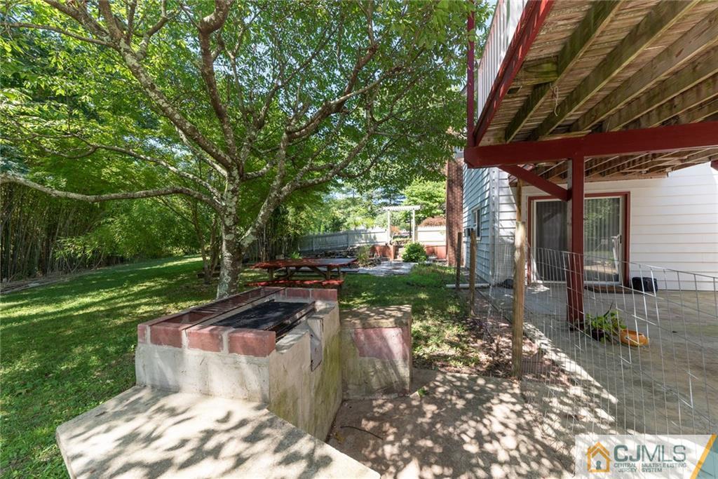 195 North New Prospect Road Jackson, NJ 08527 - Photo 24 of 25 a view of a backyard with table and chairs with wooden fence and plants