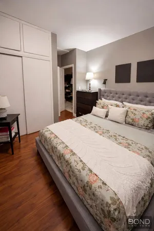 a spacious bedroom with a bed and a flat screen tv