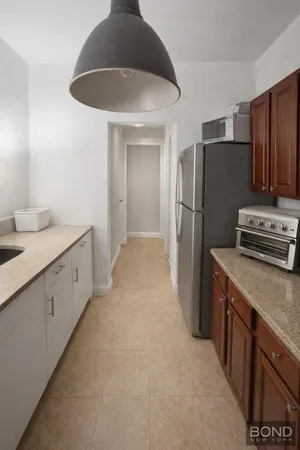 a kitchen with stainless steel appliances granite countertop a refrigerator a stove and a sink