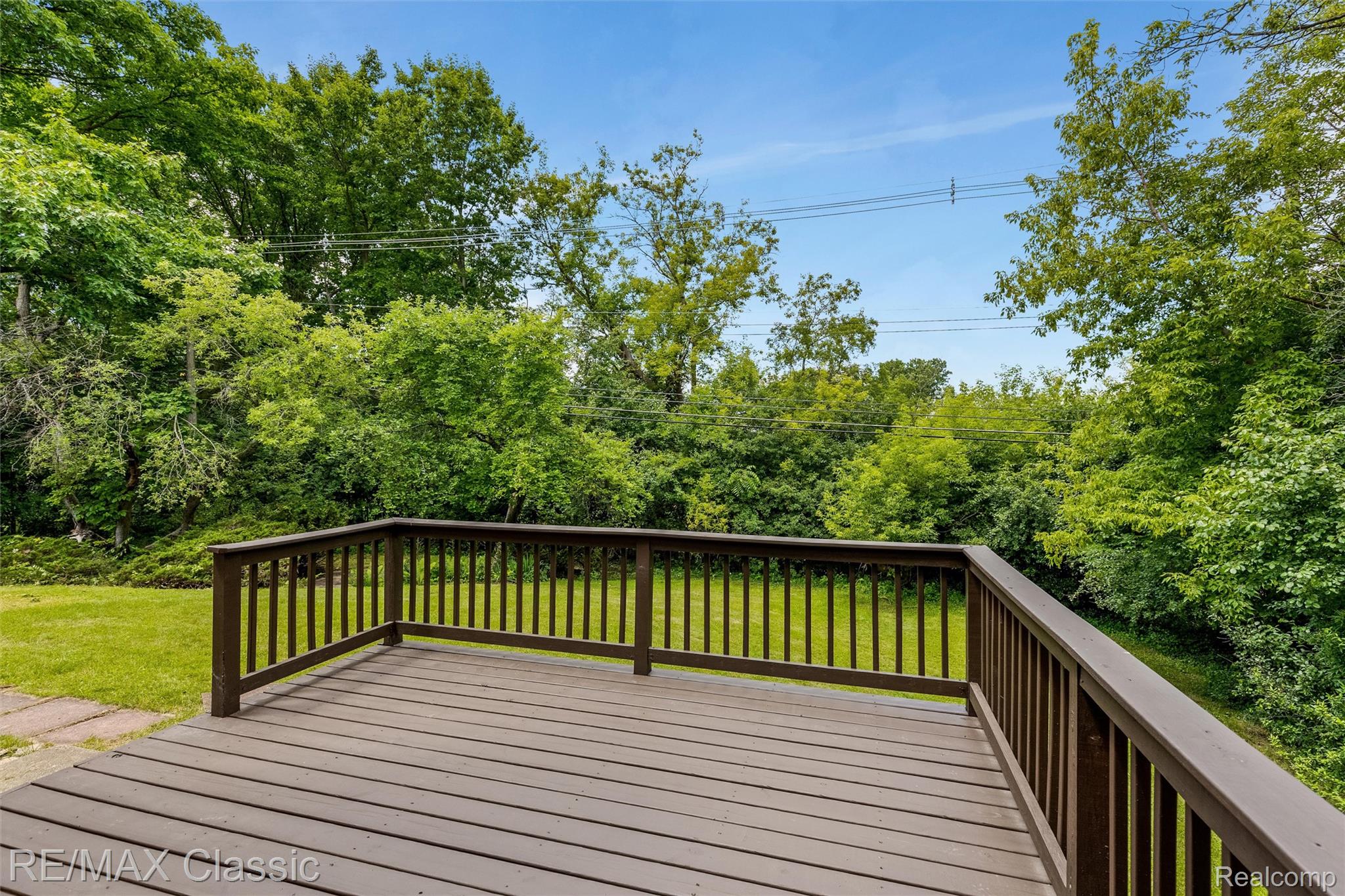 4268 Covered Bridge Road Bloomfield Hills, MI 48302 - Photo 31 of 35 Spacious outdoor deck with a dark wood-finish surface and matching railings