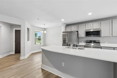 a kitchen with a dining table chairs and refrigerator