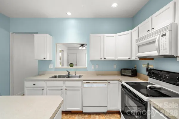 a kitchen with cabinets appliances a sink and a counter top space